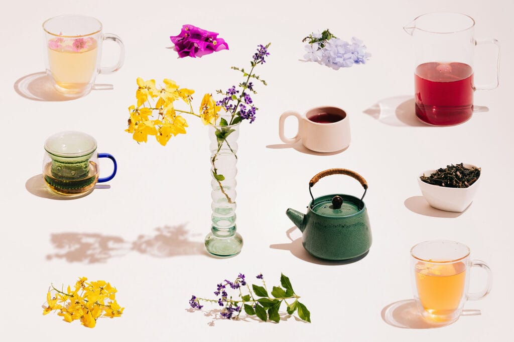 Herbata i kwiaty w filiżankach i dzbankach na jasnym tle, pokazujące różnorodne herbaty, zioła i kwiatowe dekoracje, idealne dla miłośników herbaty i relaksu.